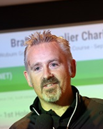 Caucasian man with spikey grey hair and beard