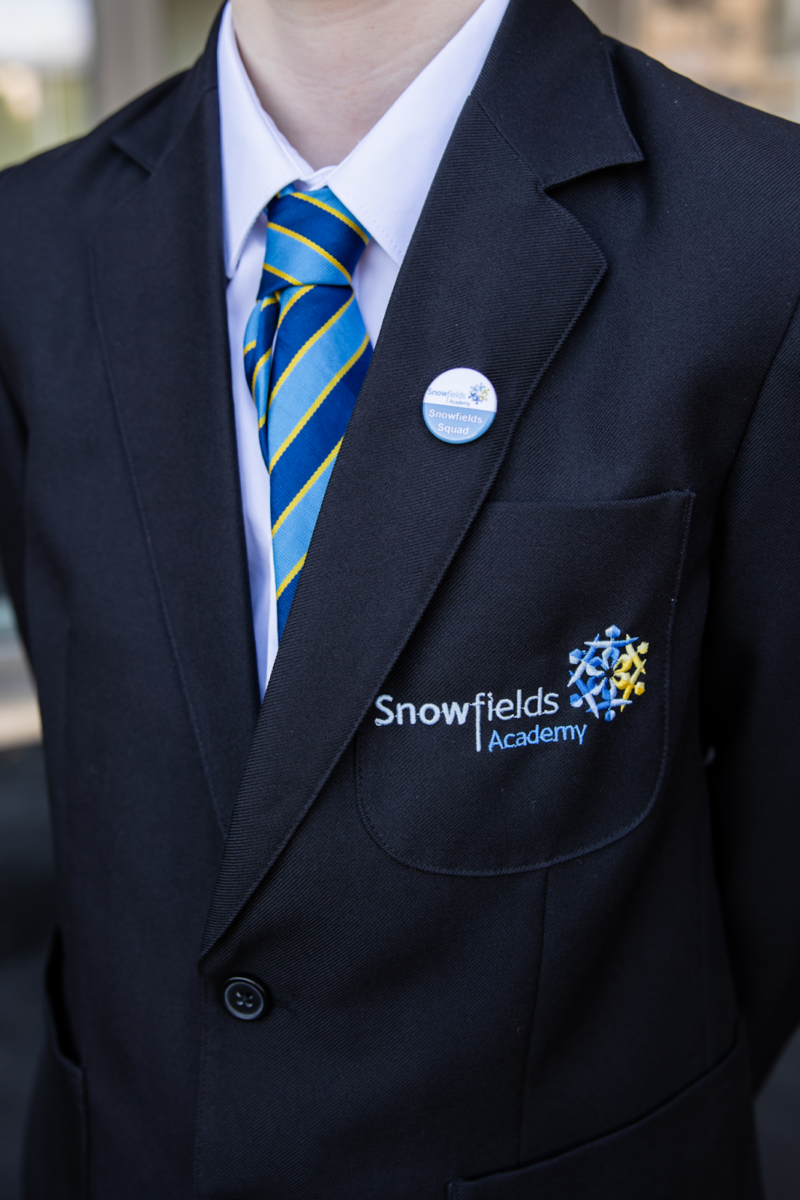 A close-up image of a 'Snowfield Squad' badge on a blazer
