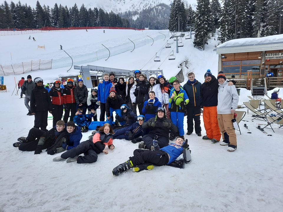A large group of students from Snowfields Academy are pictured smiling together in a snowy location, alongside their teachers, during a Skiing Trip abroad.
