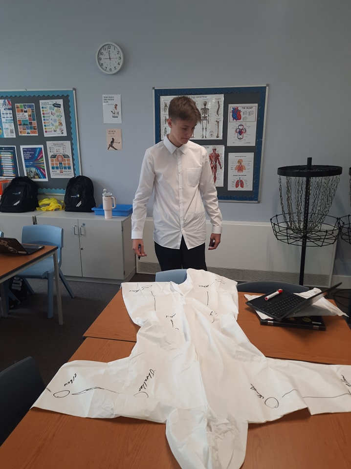 A student drawing on a lab coat