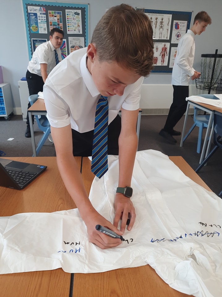 A student drawing on a lab coat