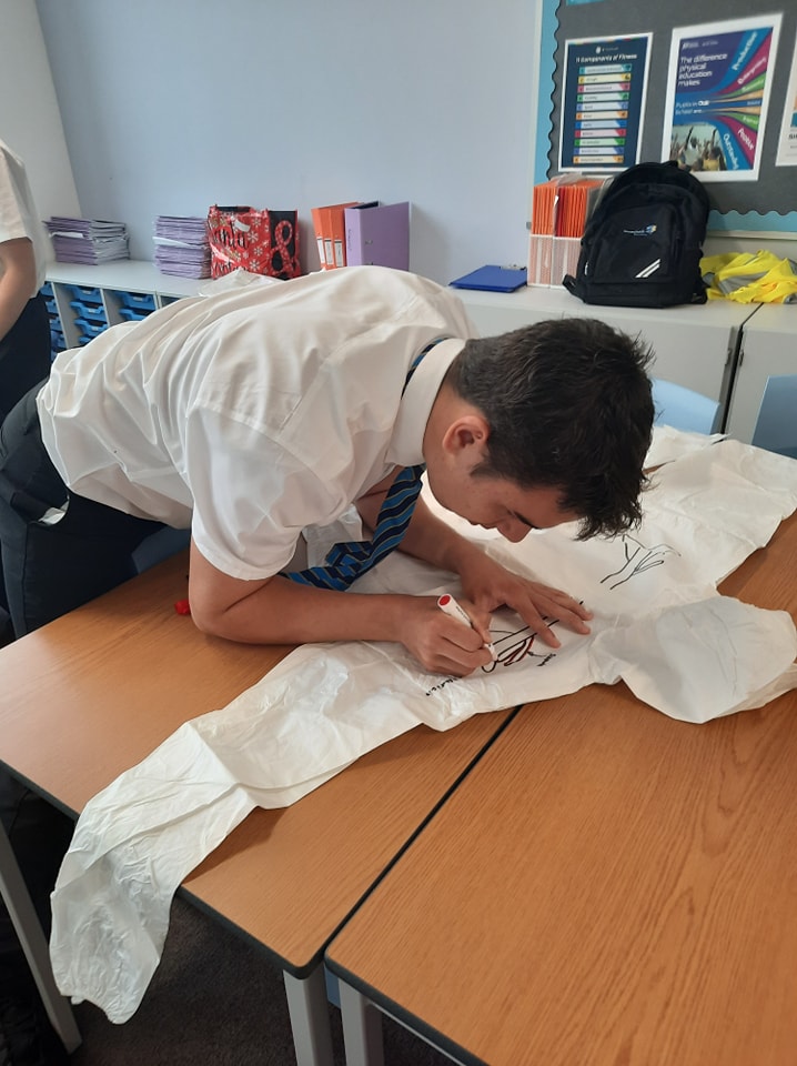 A student drawing on a lab coat