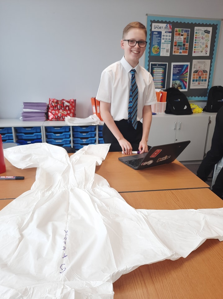 A student drawing on a lab coat