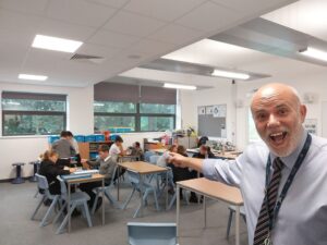 A teacher taking a selfie in front of his class