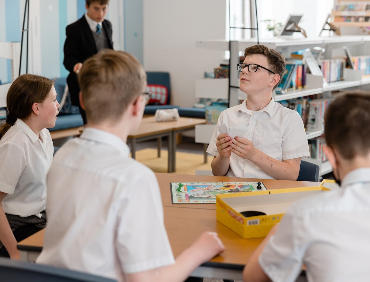 Students at a table around a board game