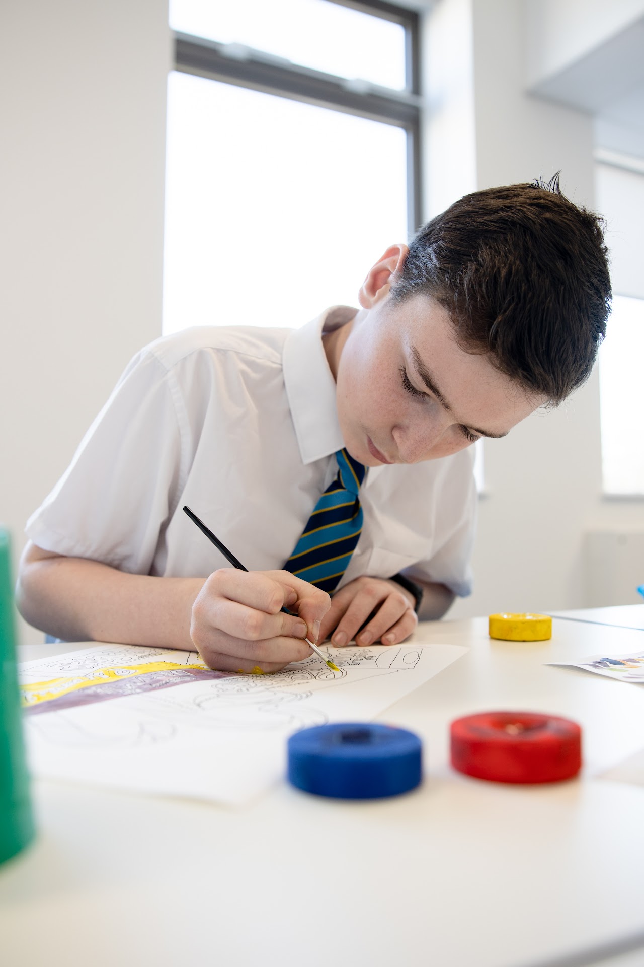 A student at a desk drawing