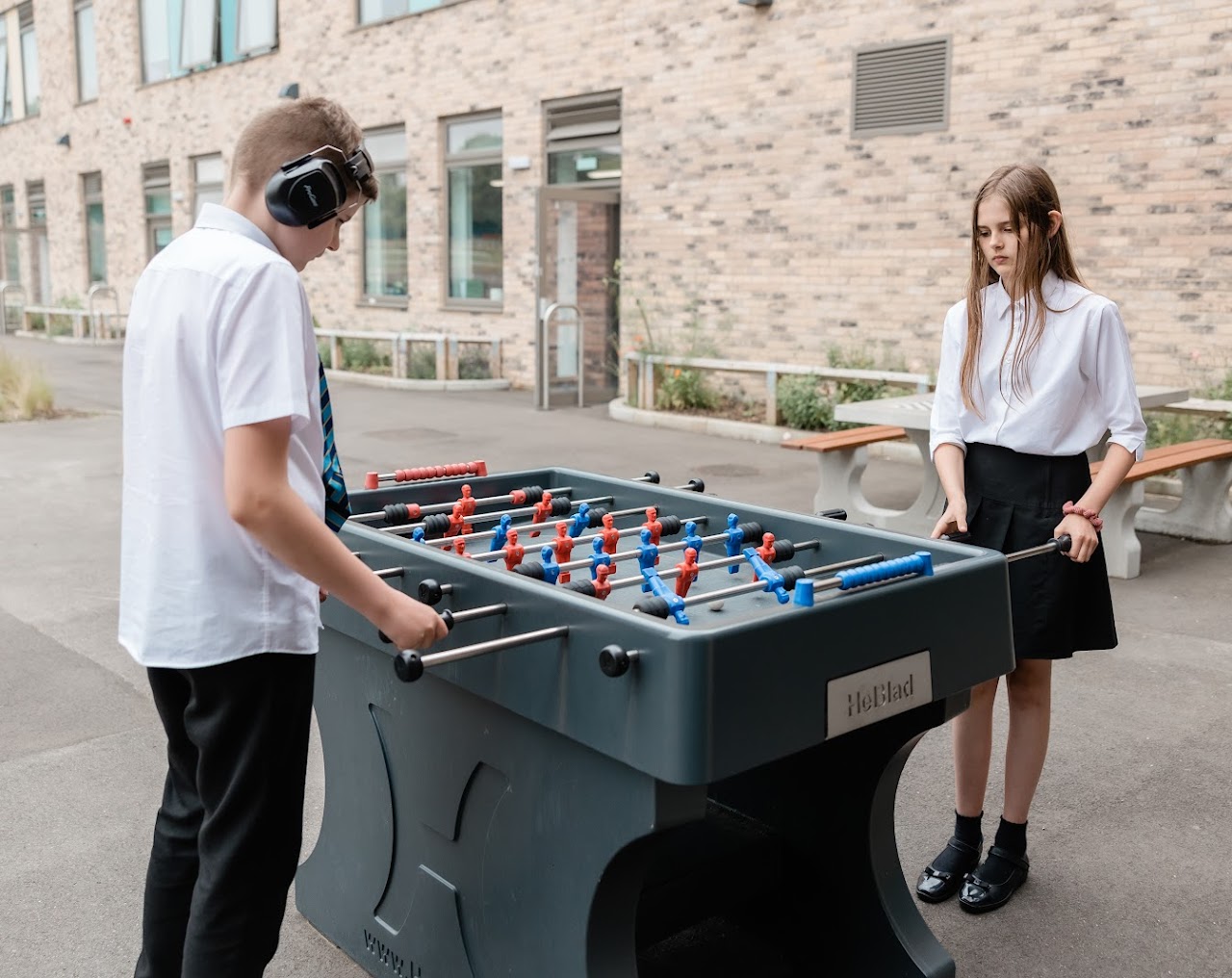 2 students outside playing table football
