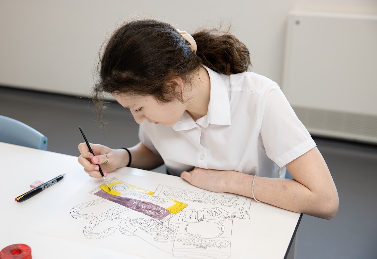A student at a desk drawing